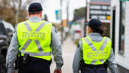 Deux auxiliaires marchant avec des gilets