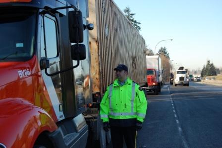 Agent debout à côté d’un camion sur la route