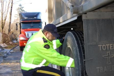 Agent évaluant le pneu d’un camion