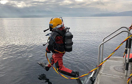 Diver stepping into the ocean